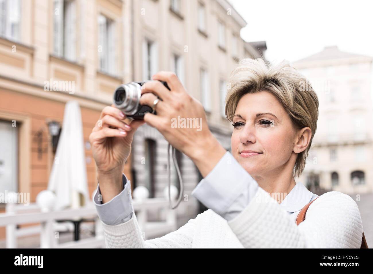 Woman photographing through digital camera in city Stock Photo