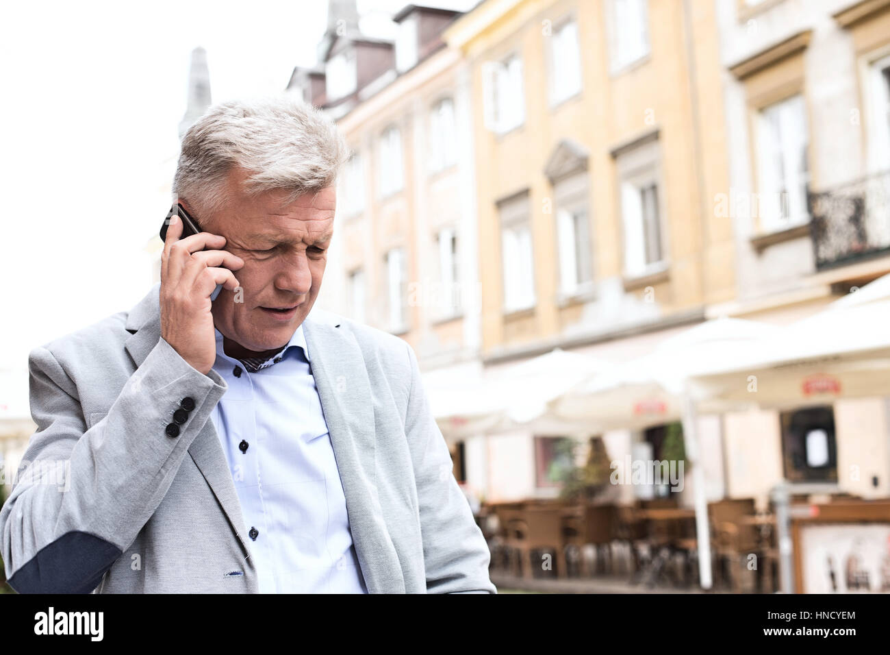 Middle-aged man using mobile phone in city Stock Photo