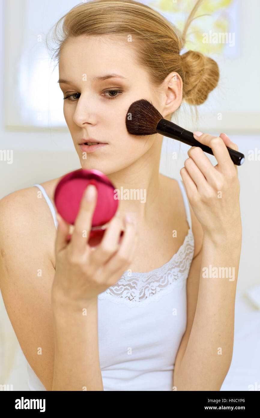 A woman applying make-up Stock Photo