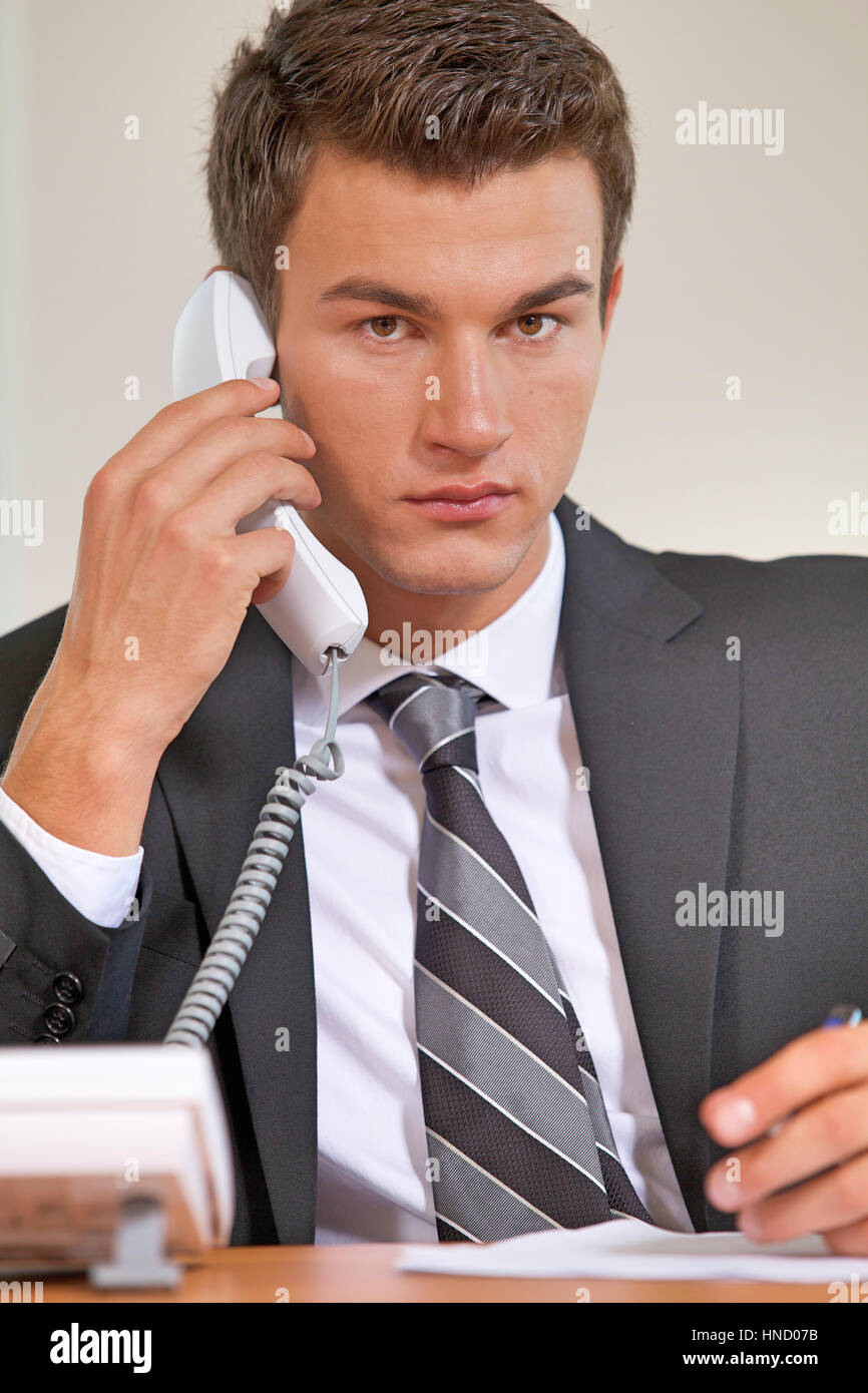 Businessman conversing on landline phone, portrait Stock Photo - Alamy