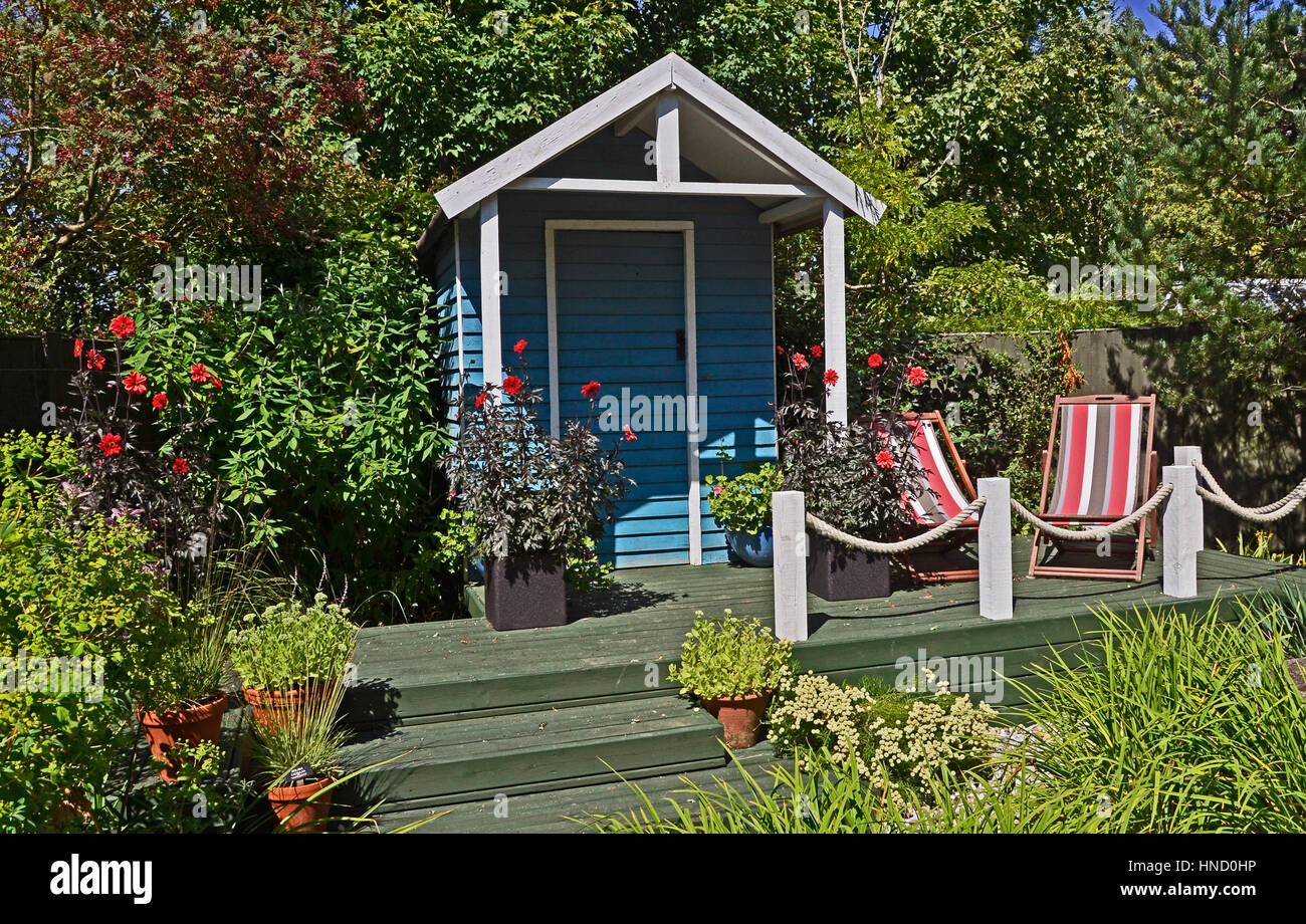 Summer House with decking, flower containers with Dahlias and seating Stock Photo