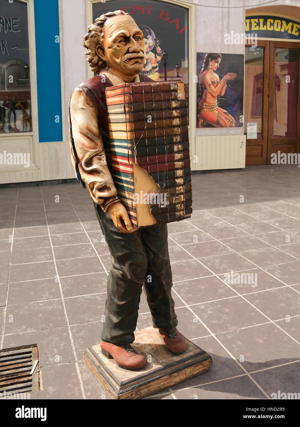 Figure of an old man carrying large stakc of books promoting bookshop. Stock Photo