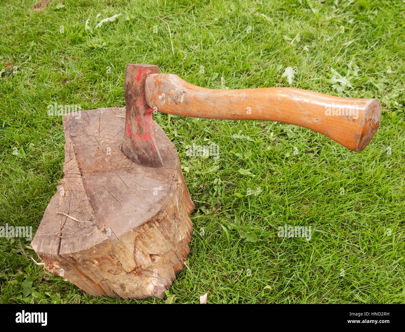 A large axe embedded in wooden block. Stock Photo