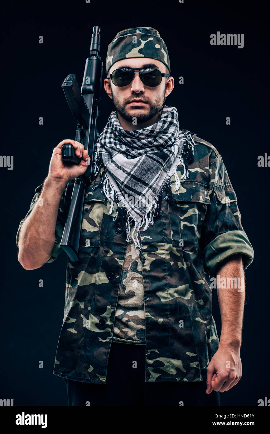 Portrait of a heavily armed masked soldier with black background concept Stock Photo