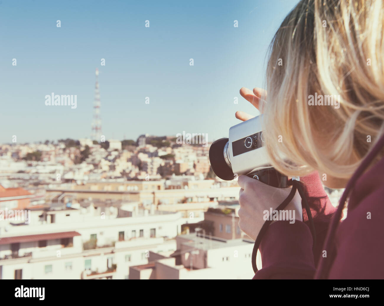 Blonde woman shooting city skyline  with vintage super 8 camera Stock Photo
