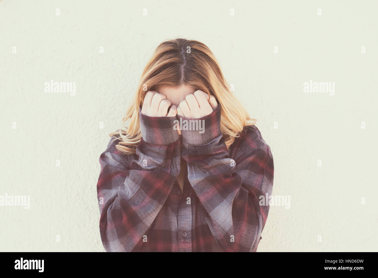 Young woman with hands over face in retro style portrait concept of fear shame and shyness, vintage retro color effect style Stock Photo