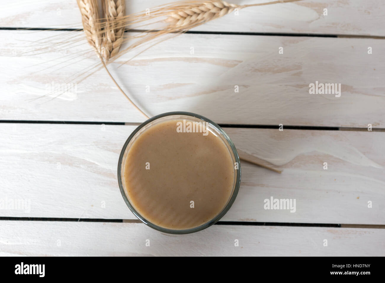 Traditional Drink from Balkan Peninsula Boza (fermented cereal beverage) and wheat over white wooden background Stock Photo