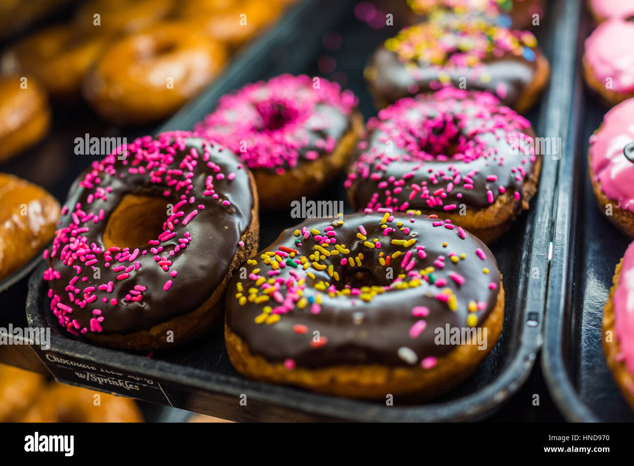 Chocolate iced donuts with pink sprinkles Stock Photo Alamy