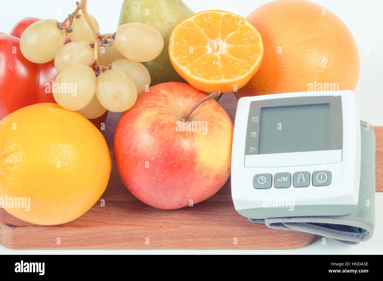 Vintage photo, Blood pressure monitor and fresh fruits with vegetables ...