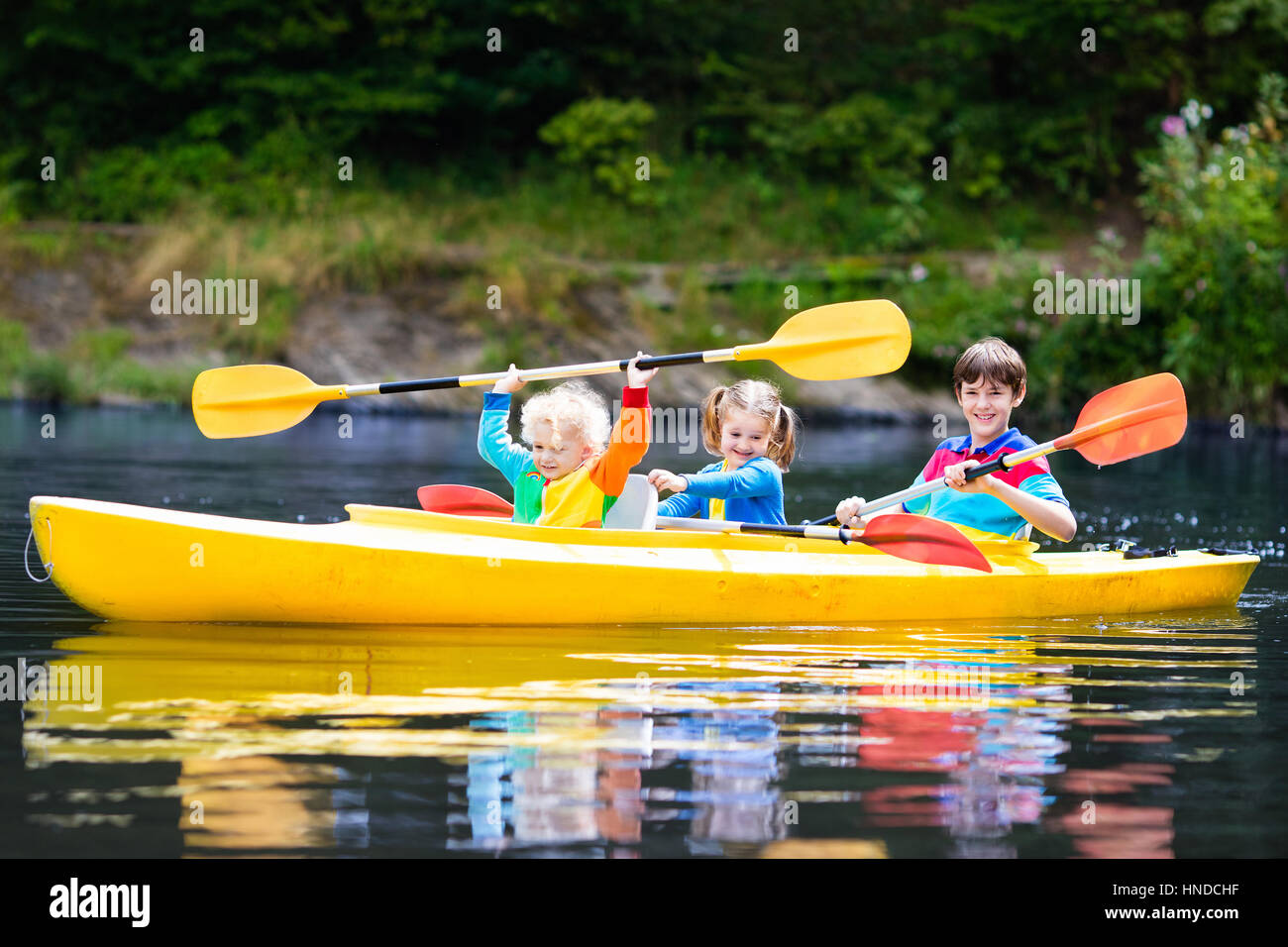 Happy family with three kids enjoying kayak ride on beautiful river ...