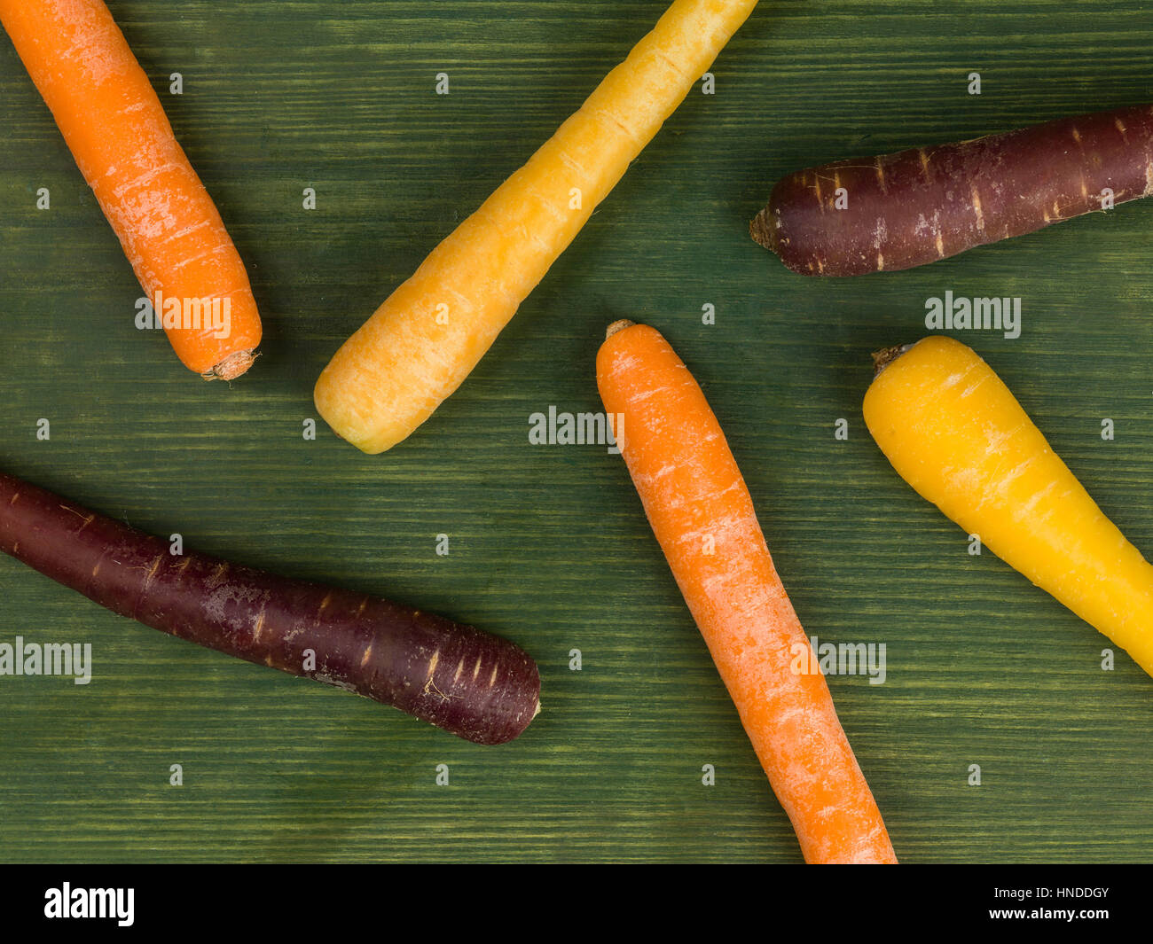 Colorful Rainbow Carrots Cooking Ingredients On A Green Background Stock Photo