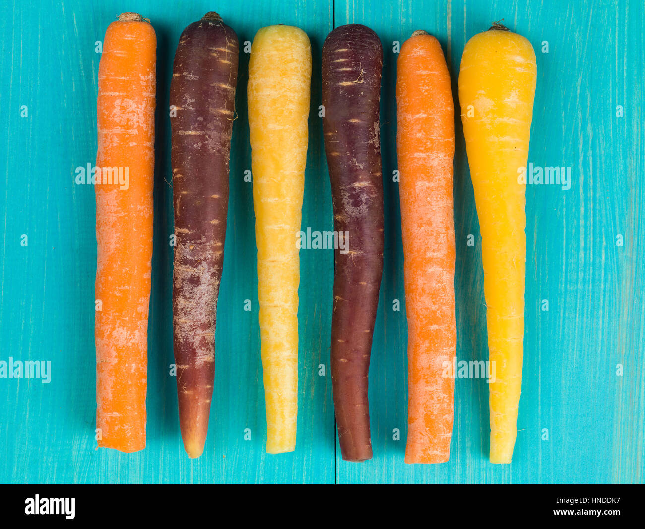 Colorful Rainbow Carrots Cooking Ingredients On A Blue Background Stock Photo