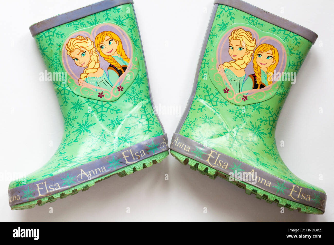 Well loved worn pair of children's wellie boots with Anna and Elsa from Frozen on set on white background Stock Photo