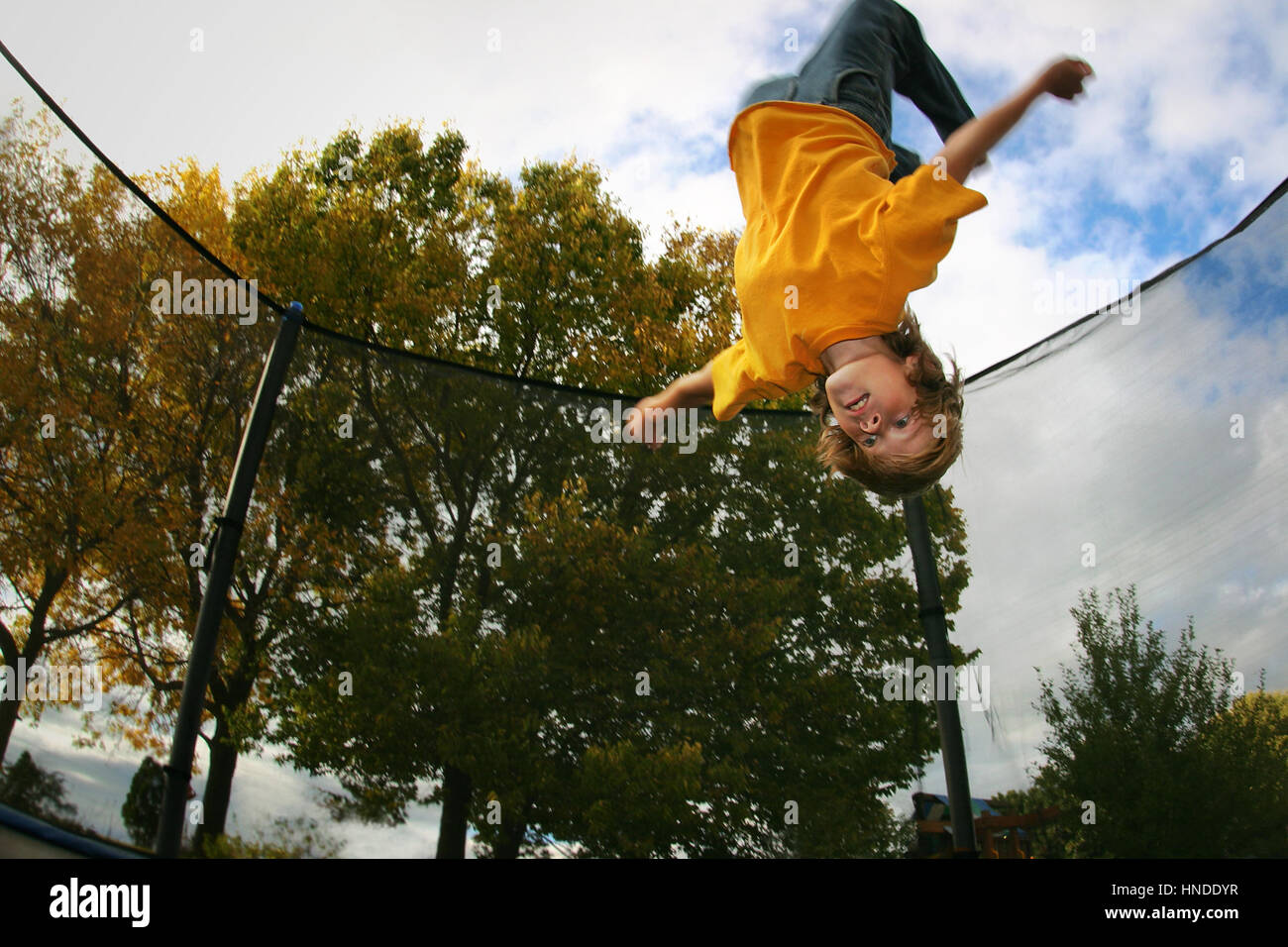 Young boy does a flip on trampoline Stock Photo - Alamy