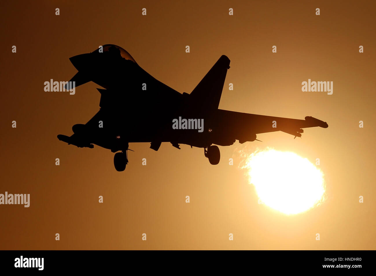 RAF Typhoon on approach to RAF Coningsby as it flies through the setting sun. Stock Photo