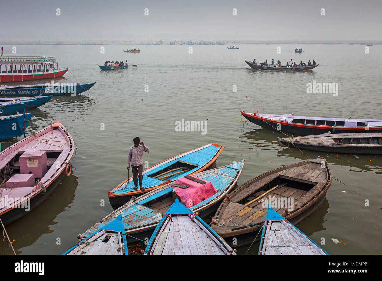 Panorama, panoramic, cityscape,Fisherman, in background boats of pilgrims, in Ganges river, Varanasi, Uttar Pradesh, India. Stock Photo