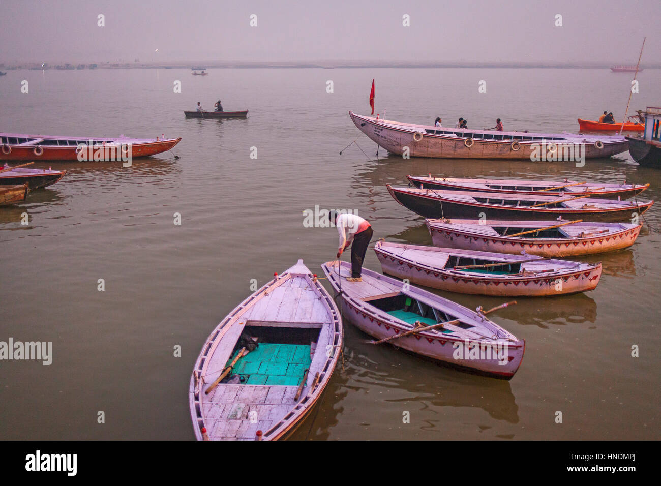 Panorama, panoramic, cityscape, Fisherman, in background boats of tourists, in Ganges river, Varanasi, Uttar Pradesh, India. Stock Photo