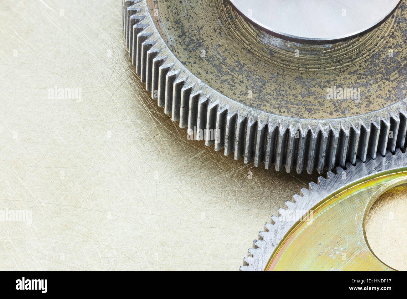 weathered gear cogwheels on brass scratched background Stock Photo