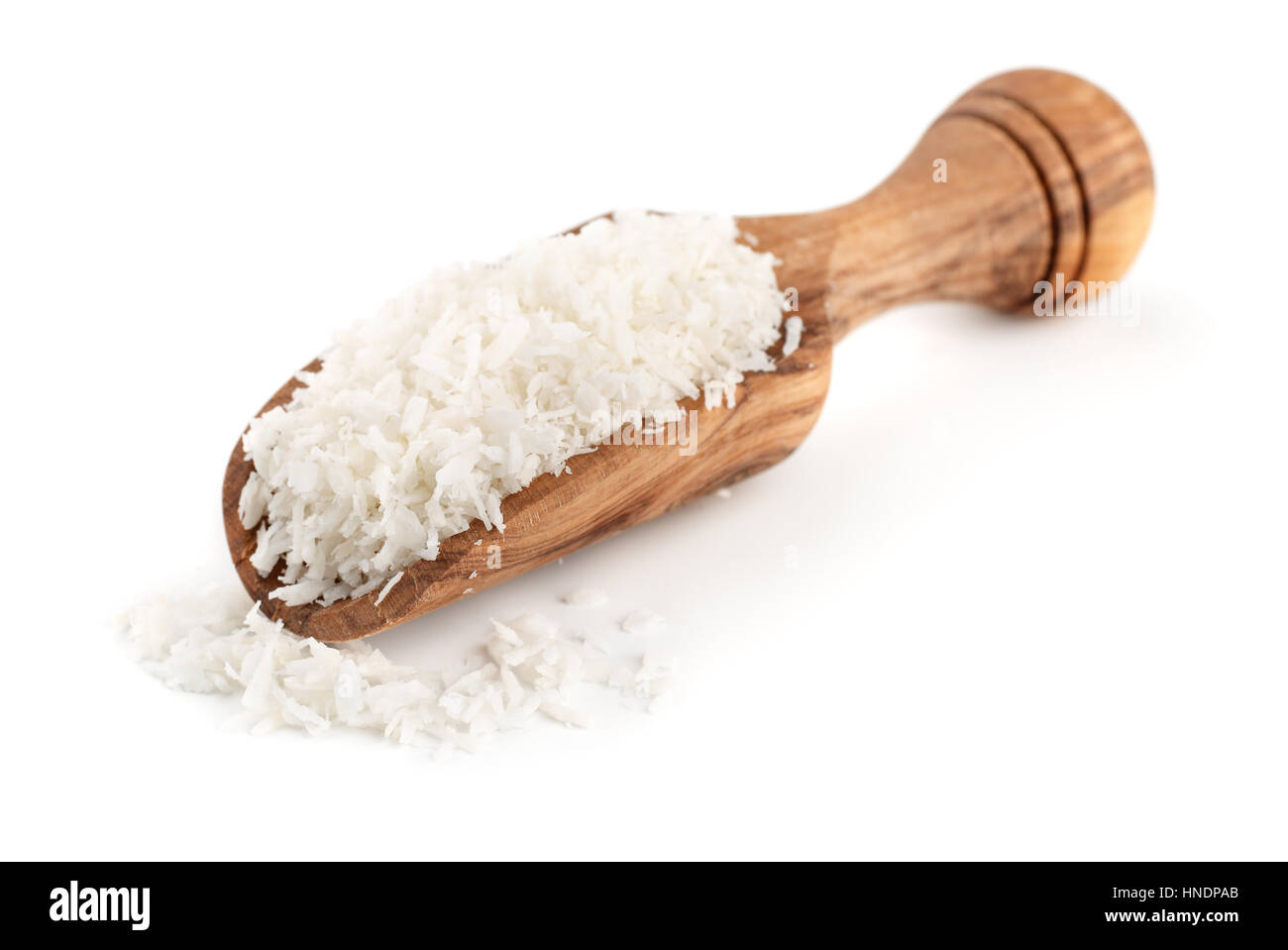 Wooden scoop full of coconut shavings isolated on white Stock Photo