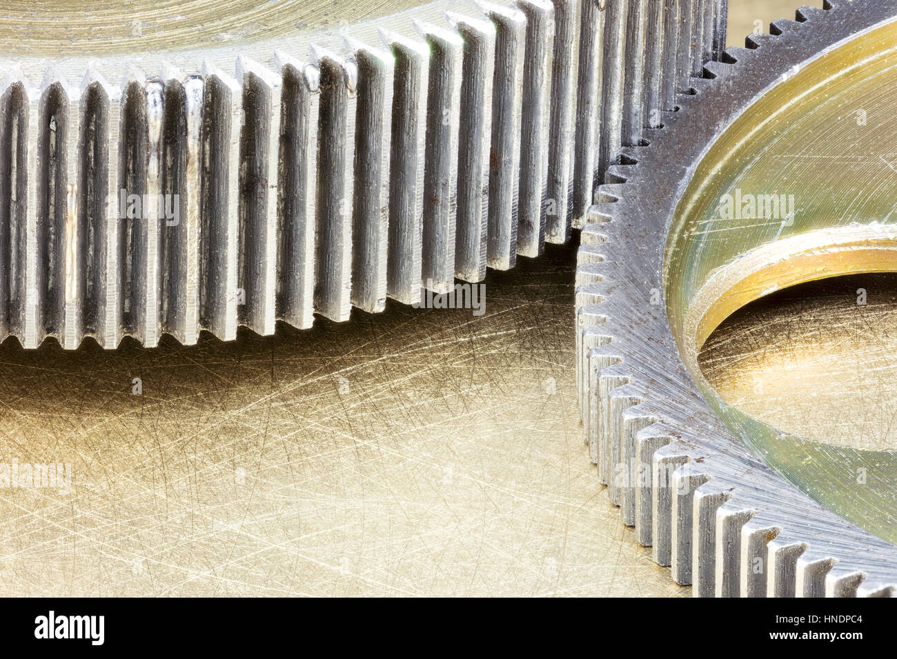 brass cogwheels on scratched metal industrial background closeup Stock Photo
