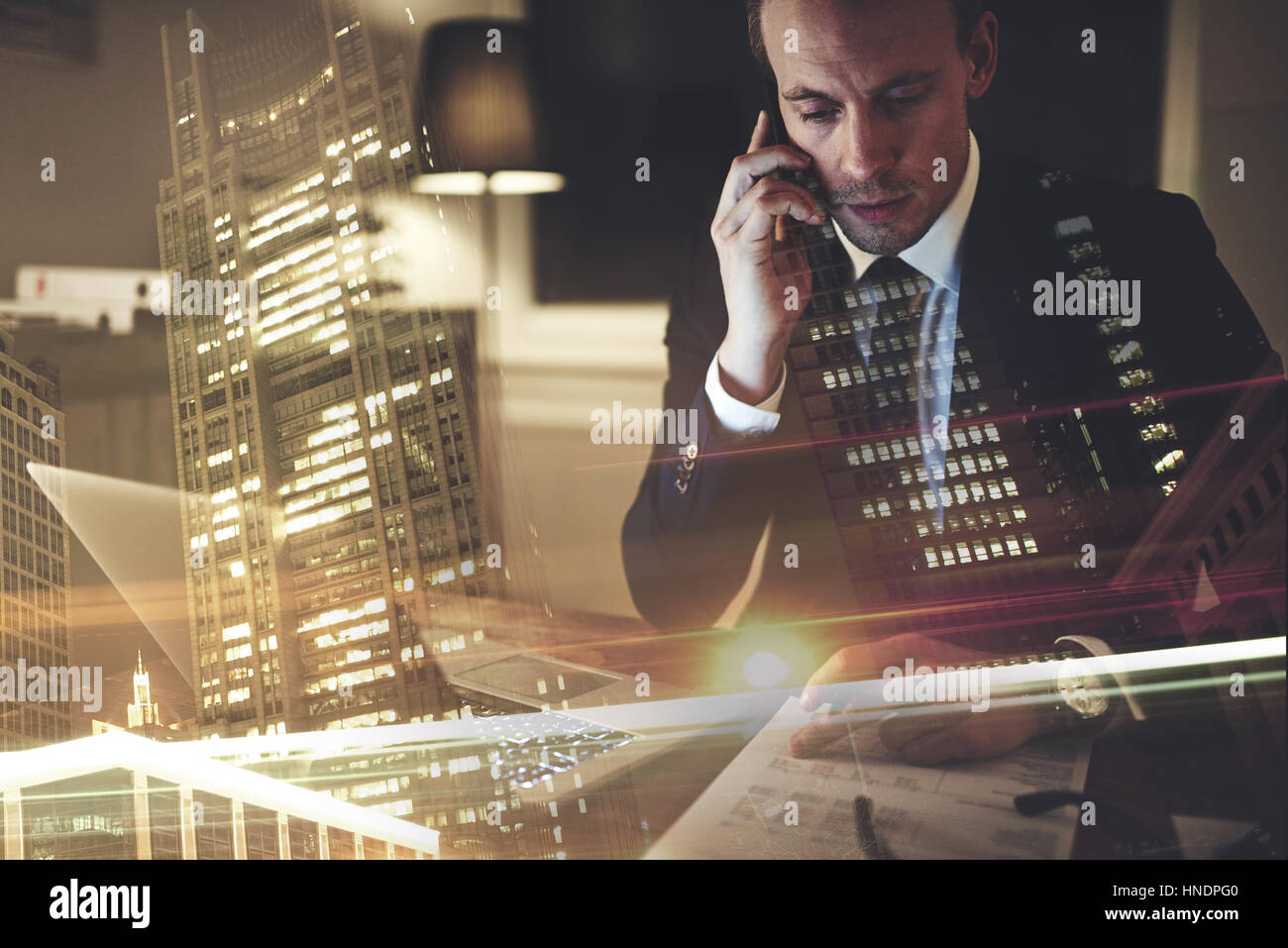 Business man speaking on the phone while sitting at his desk with documents Stock Photo