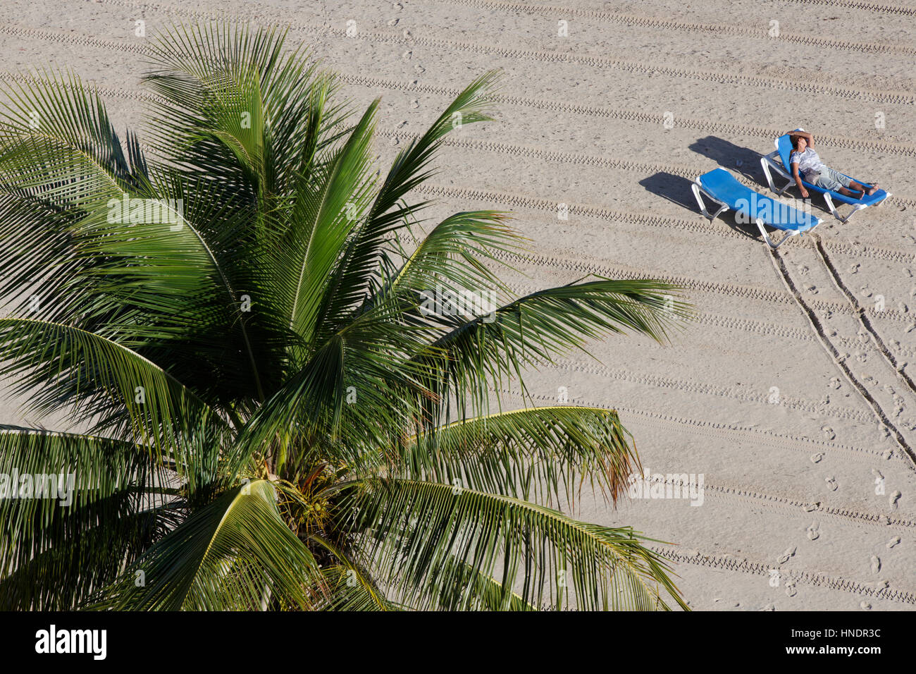 Elevated view of a person on a tropical Isla Verde beach on a chaise lounge,  Carolina, San Juan, Puerto Rico Stock Photo