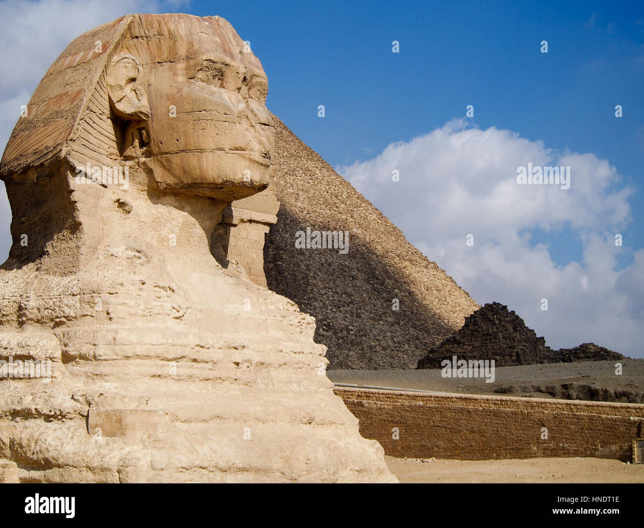 Ancient sphinx statue in front of the Great Pyramids of Giza in the