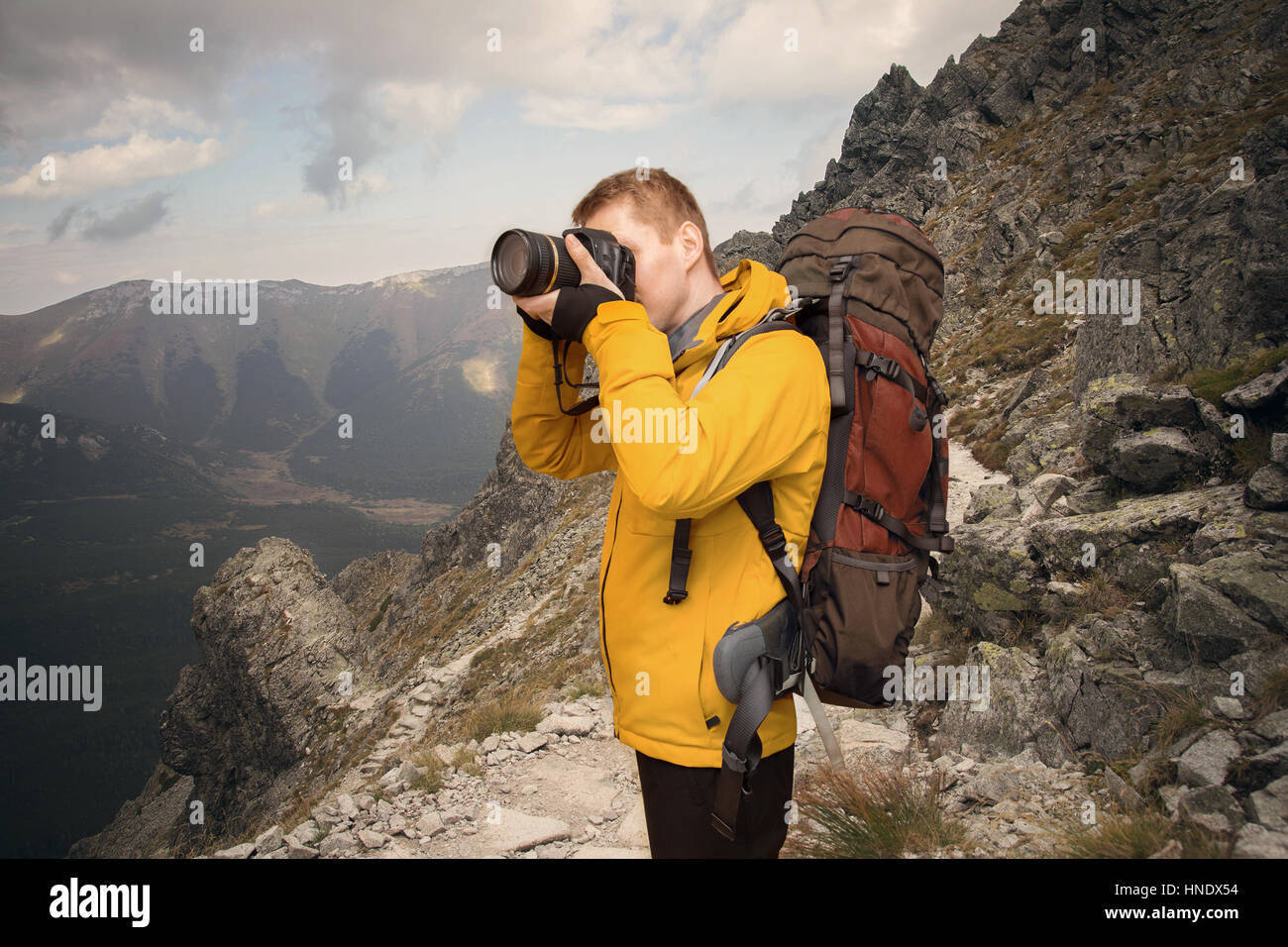 hiker photographing in mountains Stock Photo