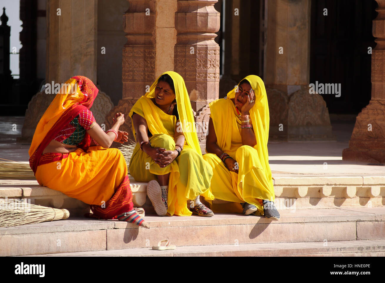 Brightly dressed ladies chatting while sitting on steps in Jaipur. Stock Photo