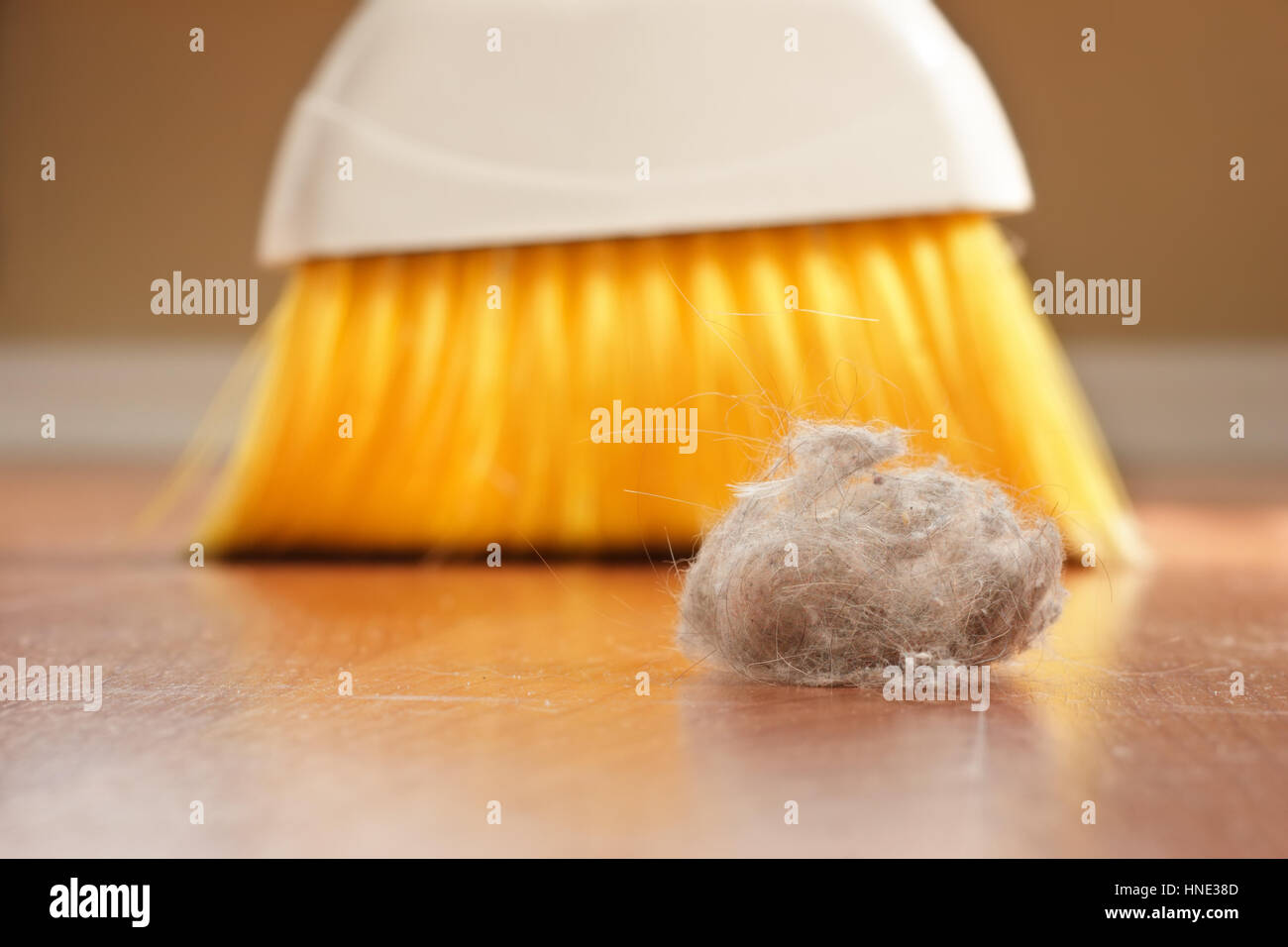 Yellow broom sweeping a giant dust ball Stock Photo Alamy