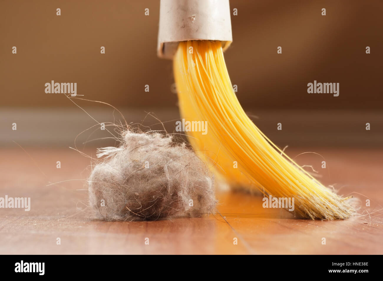 Yellow broom sweeping a giant dust ball Stock Photo Alamy