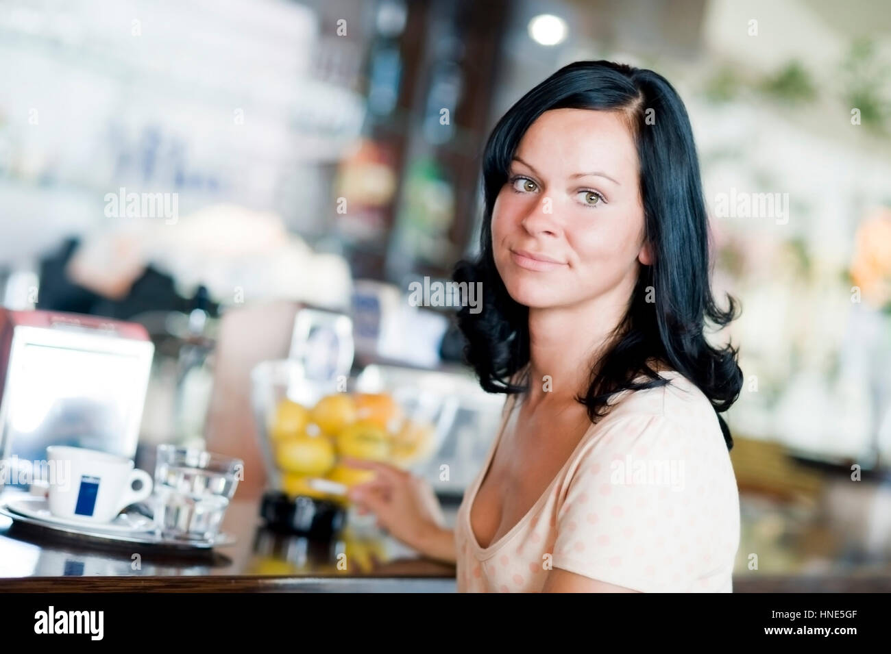 Model release, Junge Frau sitzt an der Theke im Kaffeehaus und raucht - young woman smoking in cafeteria Stock Photo