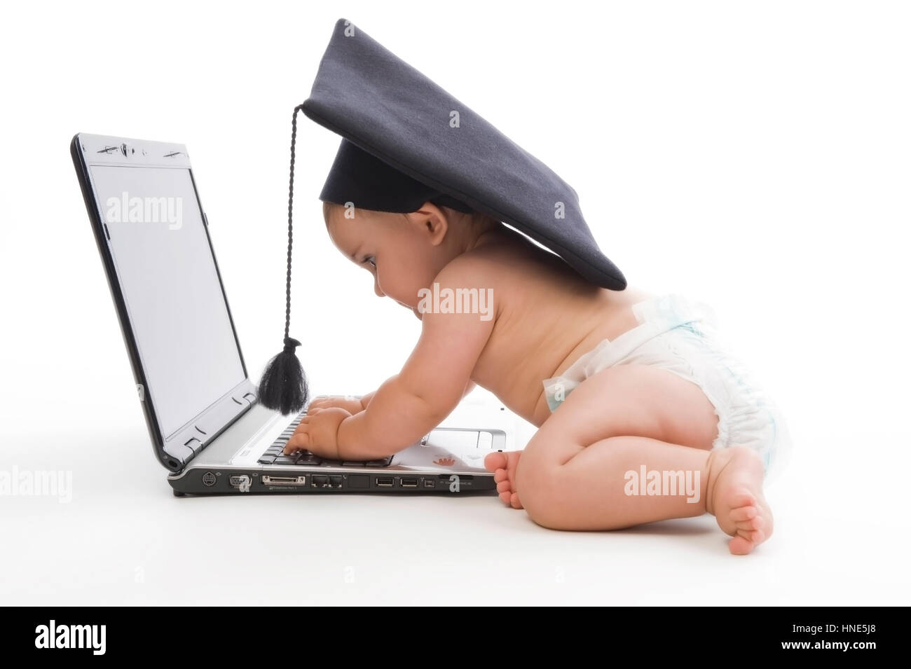 Model release, Kleinkind, 8 Monate, mit Doktorhut und Laptop - little child with doctoral cap using laptop Stock Photo