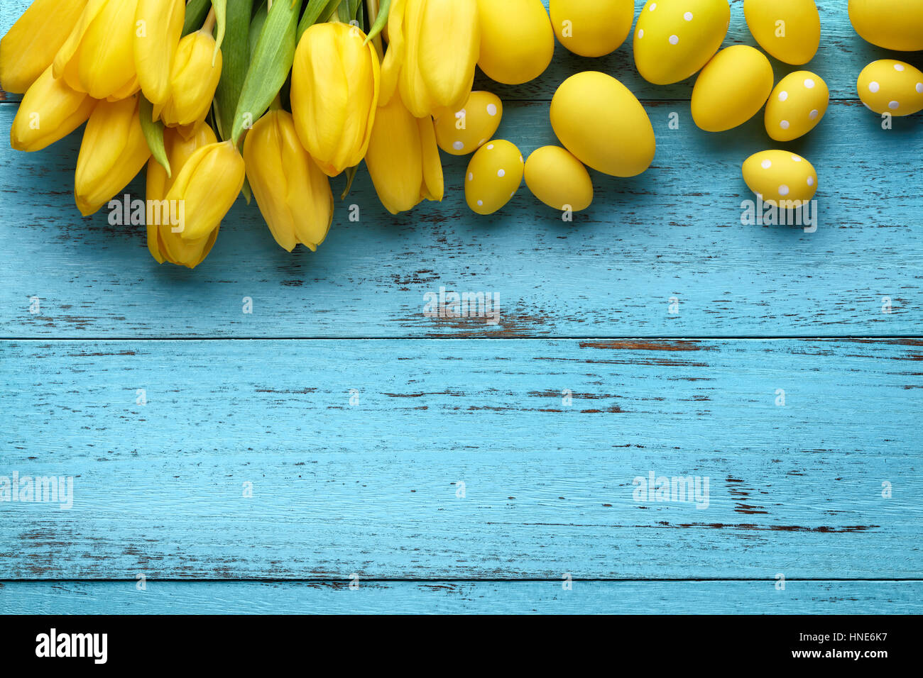 Yellow tulip flower and easter eggs on rustic wooden background Stock Photo