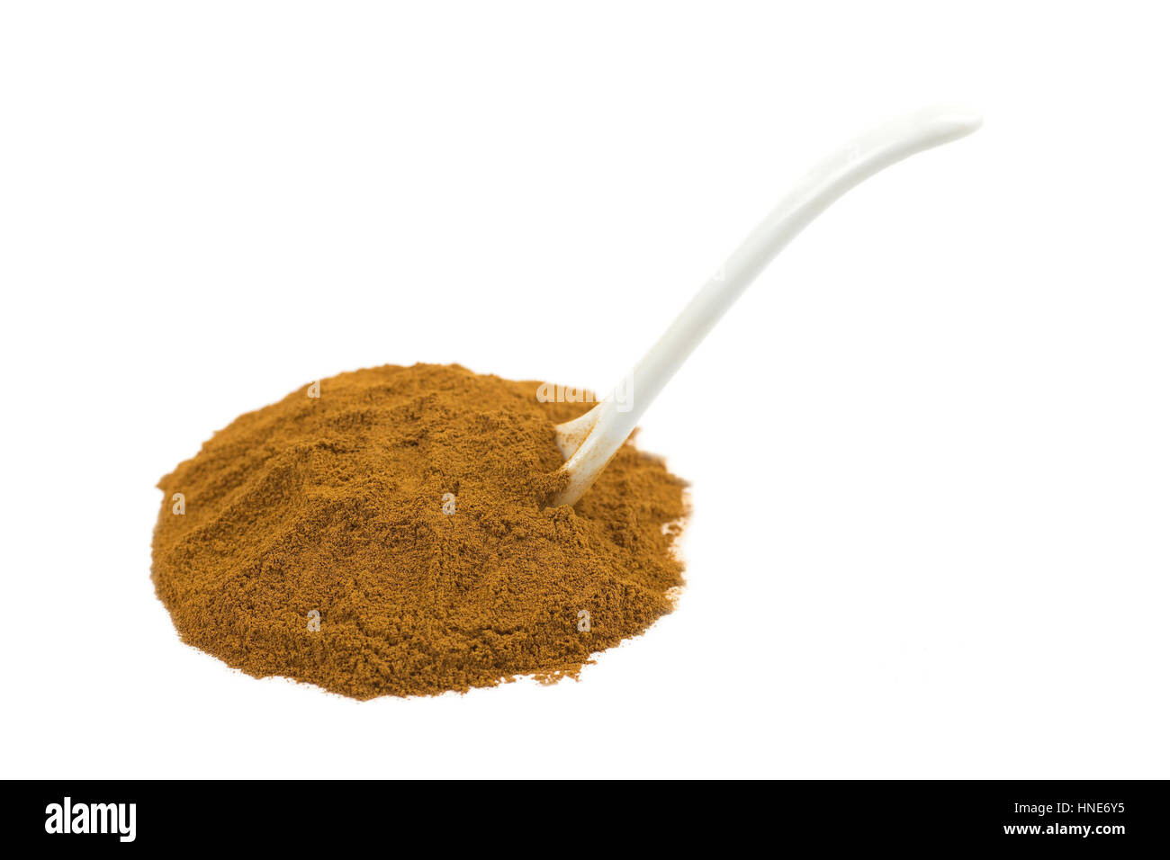 Spoon in heap of cinnamon powder isolated on white background Stock Photo