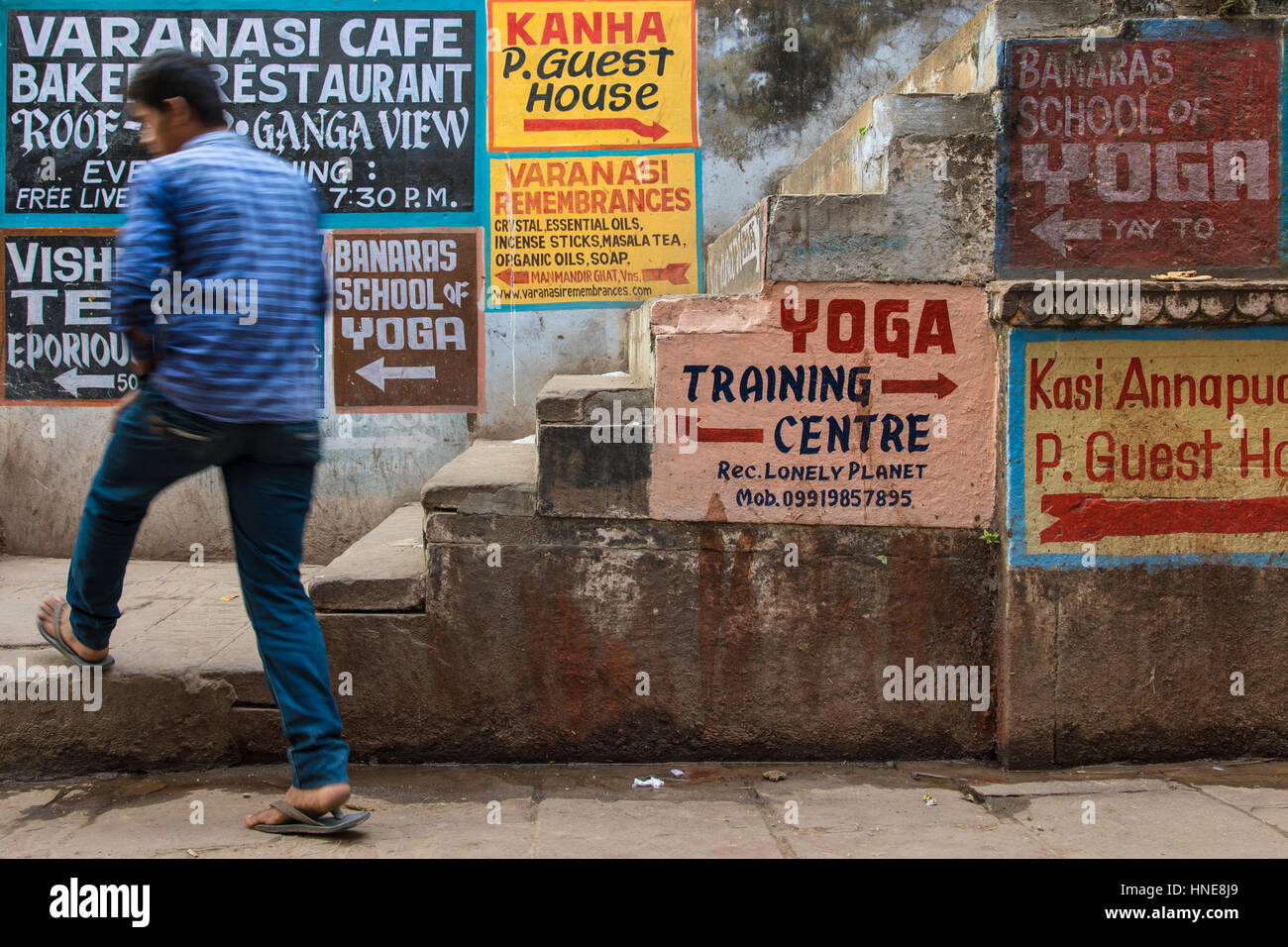 Hand painted signs advertising yoga lodges, music schools and restaurants in Varanasi, India, one of the country's most popular tourist destinations. Stock Photo
