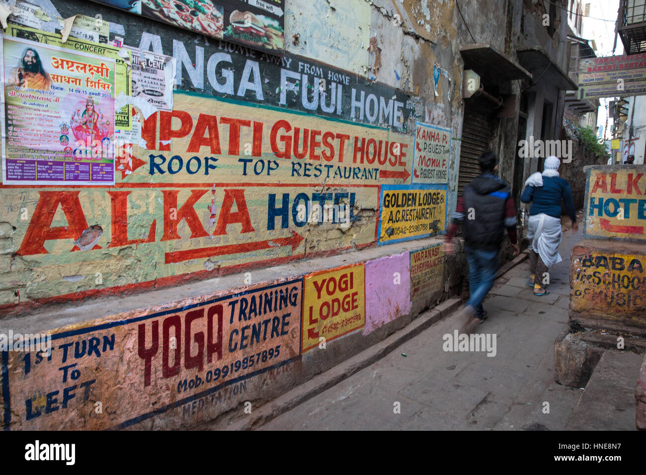 Hand painted signs advertising yoga lodges, music schools and restaurants in Varanasi, India, one of the country's most popular tourist destinations. Stock Photo