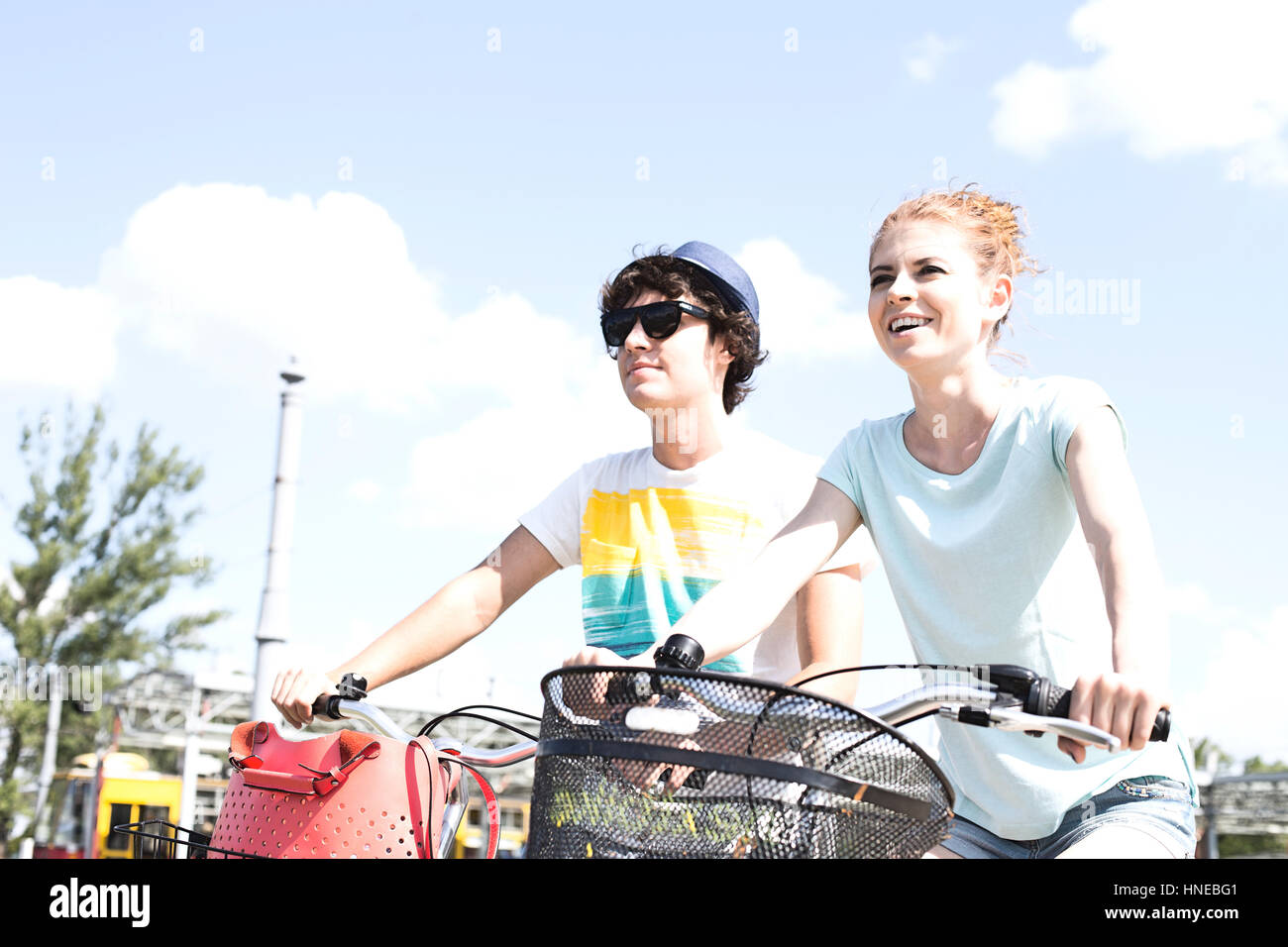 Smiling couple cycling against sky Stock Photo