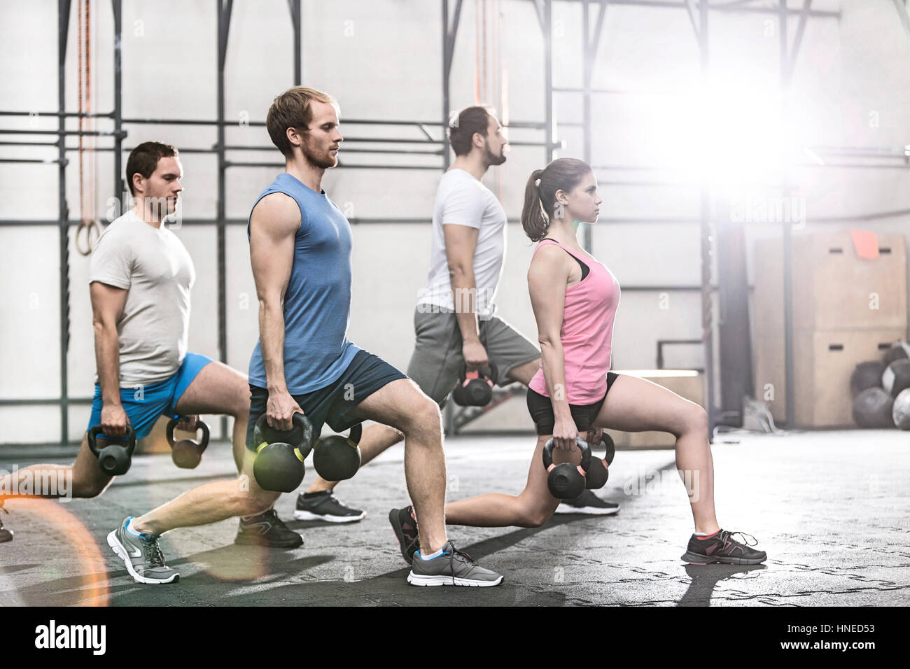 Determined people lifting kettlebells at crossfit gym Stock Photo