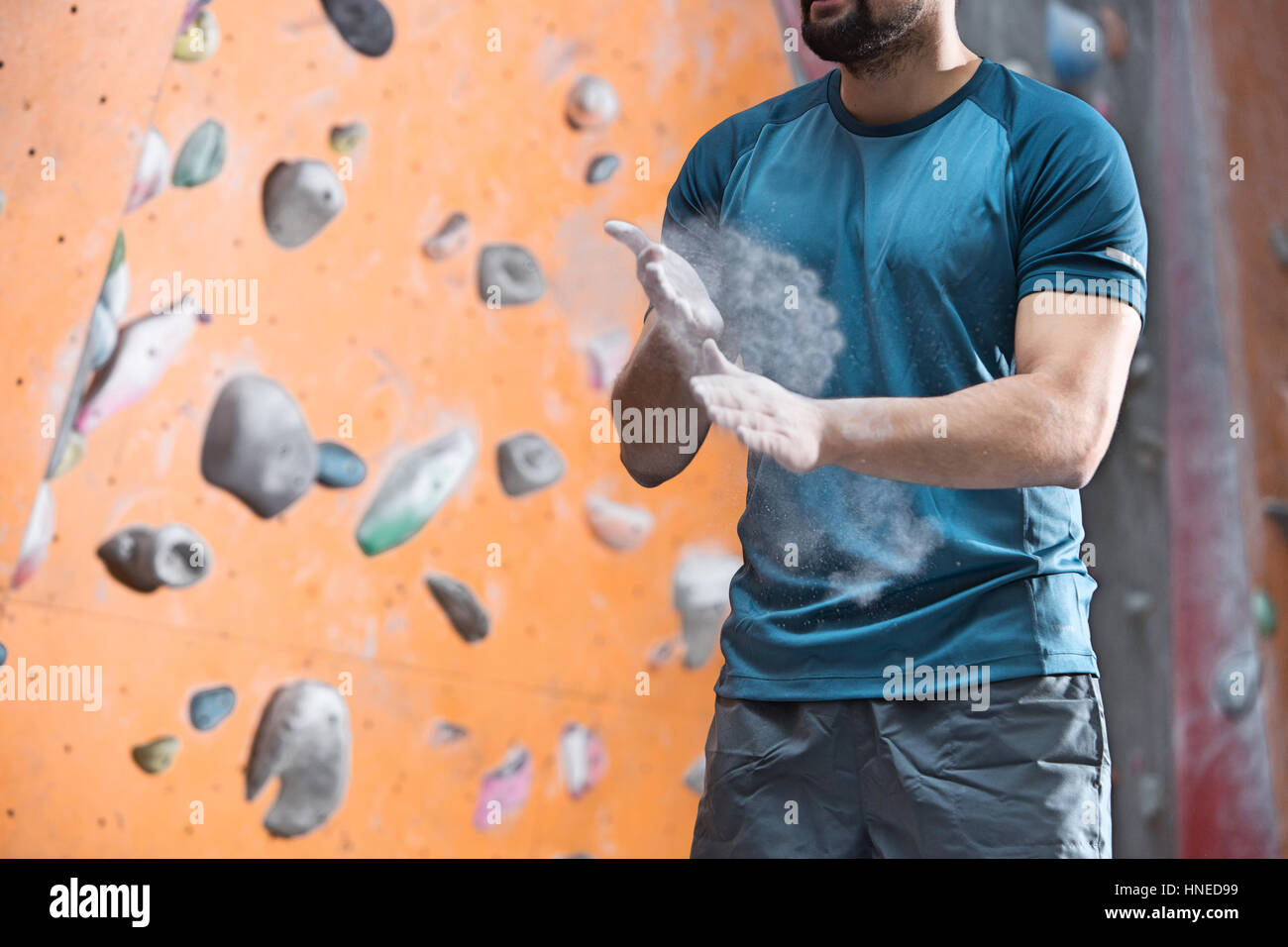 Midsection of man dusting powder by climbing wall in crossfit gym Stock ...