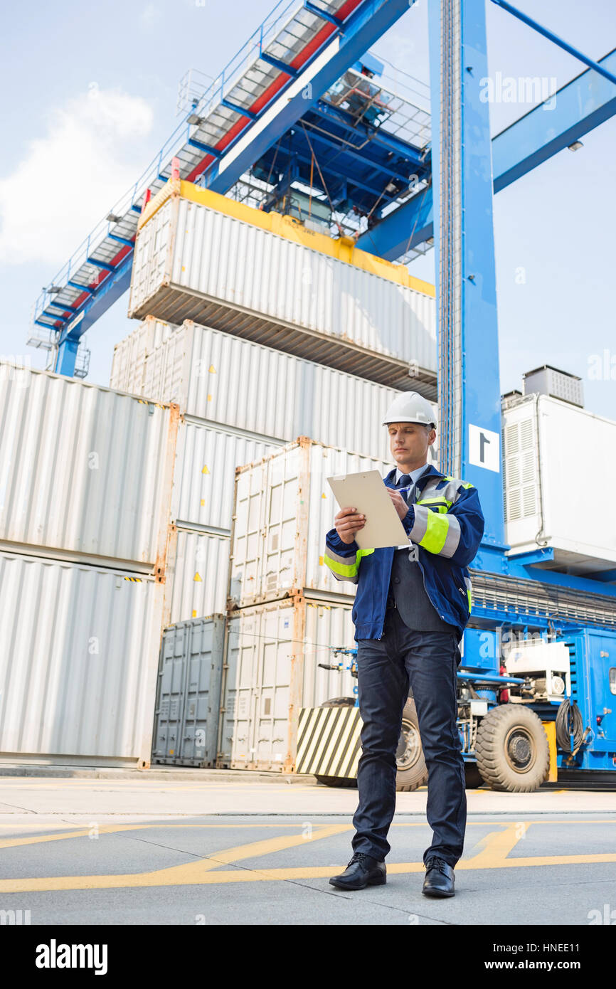 Fulllength of male supervisor writing on clipboard in shipping yard