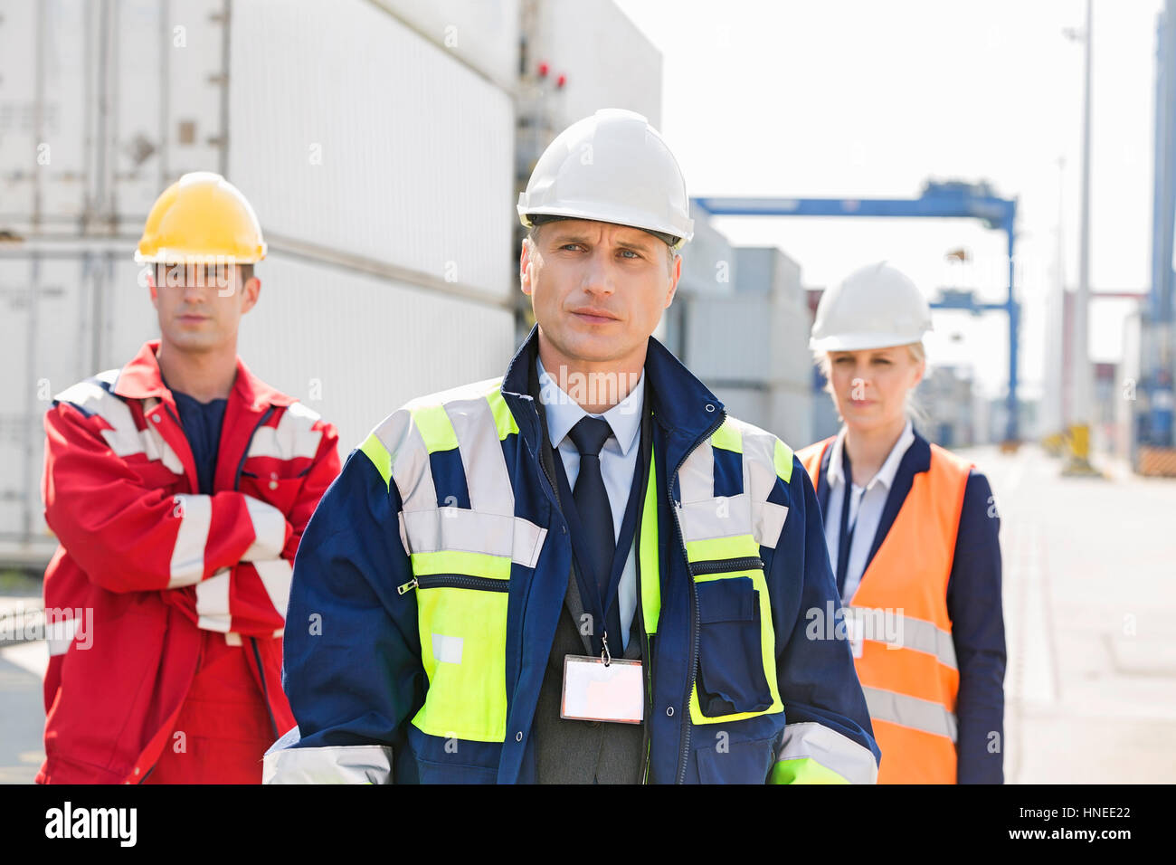 Confident workers standing in shipping yard Stock Photo