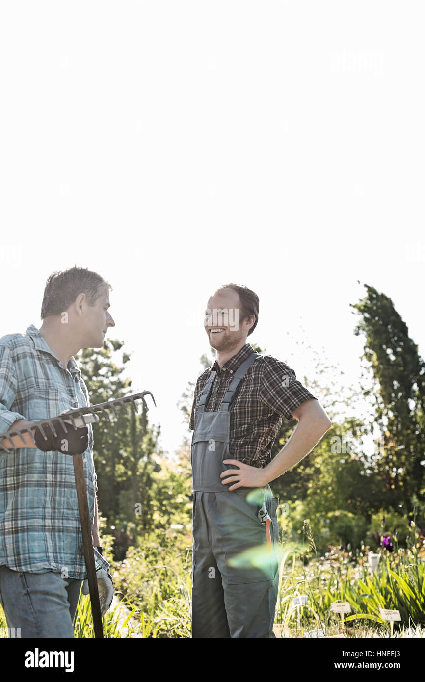 Happy gardeners conversing at plant nursery Stock Photo
