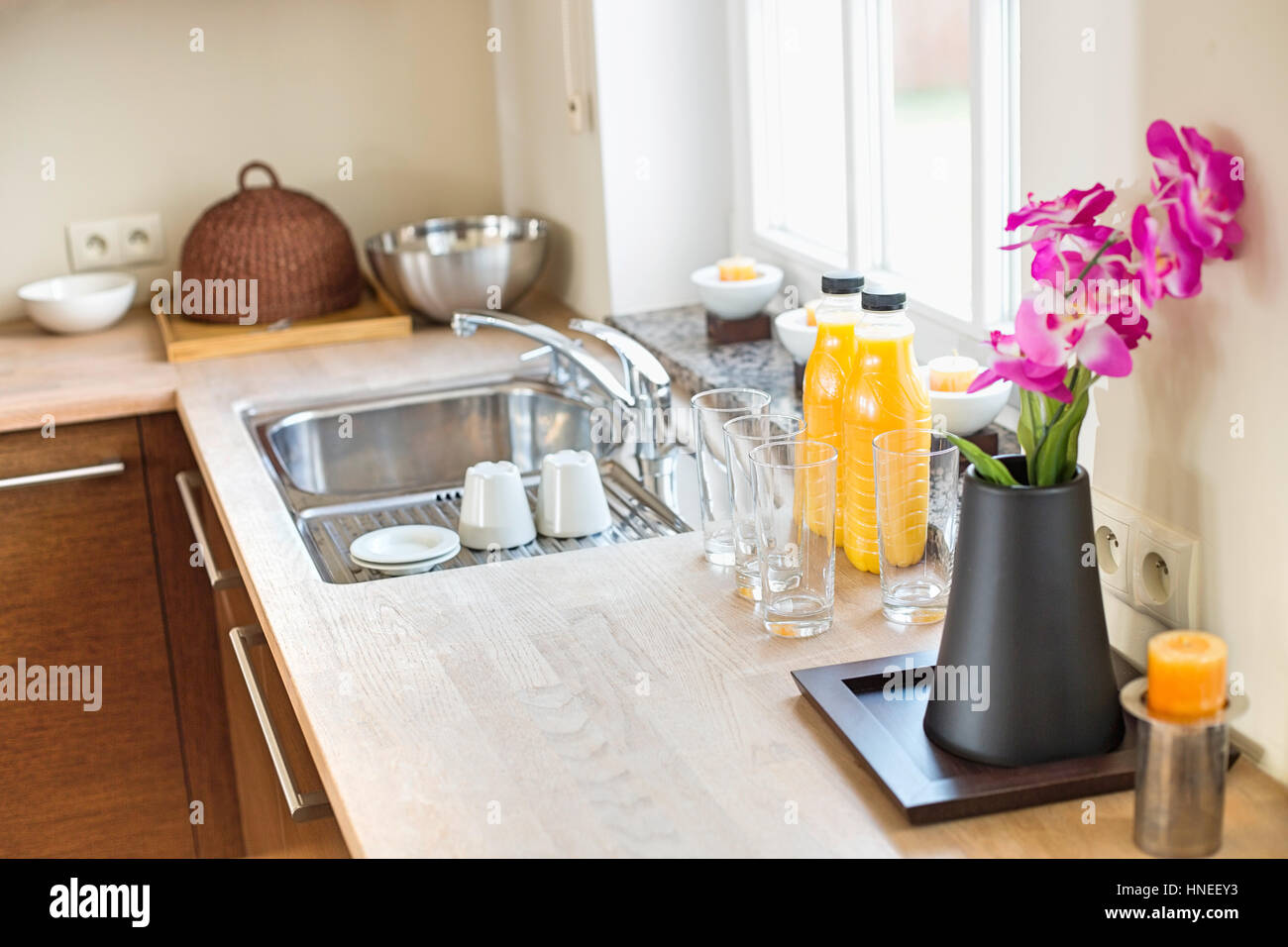 Flower vase with juice bottles on kitchen counter Stock Photo Alamy