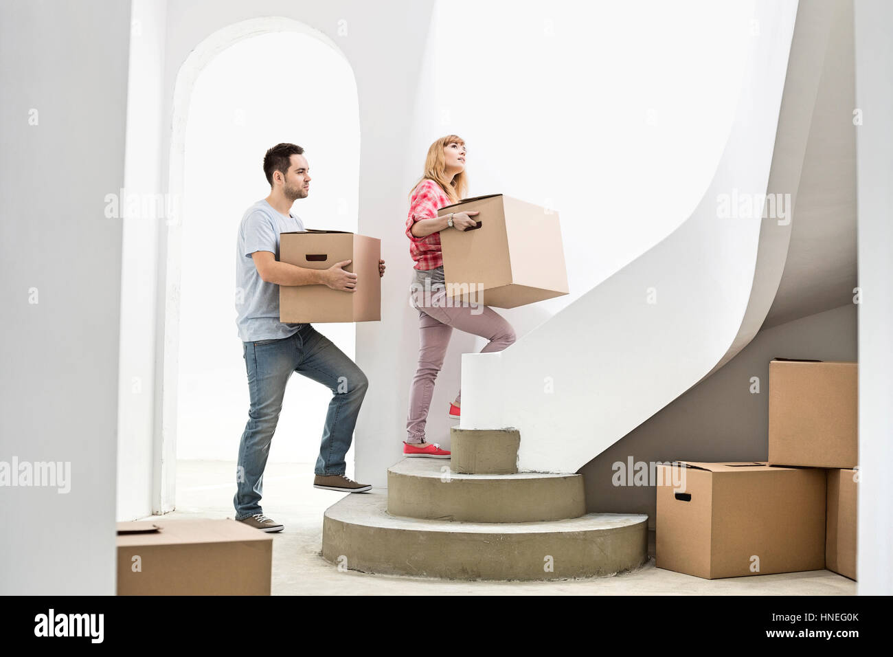 Couple carrying cardboard boxes up stairs in new house Stock Photo Alamy