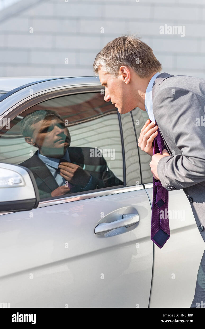 Businessman Adjusting Tie While Looking In Car Window Stock Photo Alamy businessman-adjusting-tie-while-looking-in-car-window-stock-photo-alamy