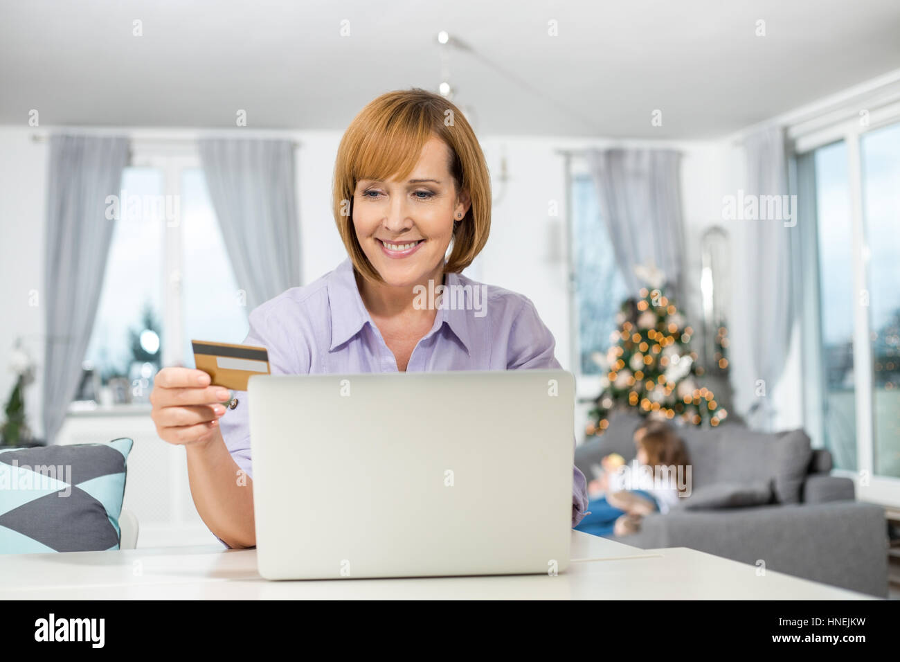 Happy woman shopping online at home during Christmas Stock Photo