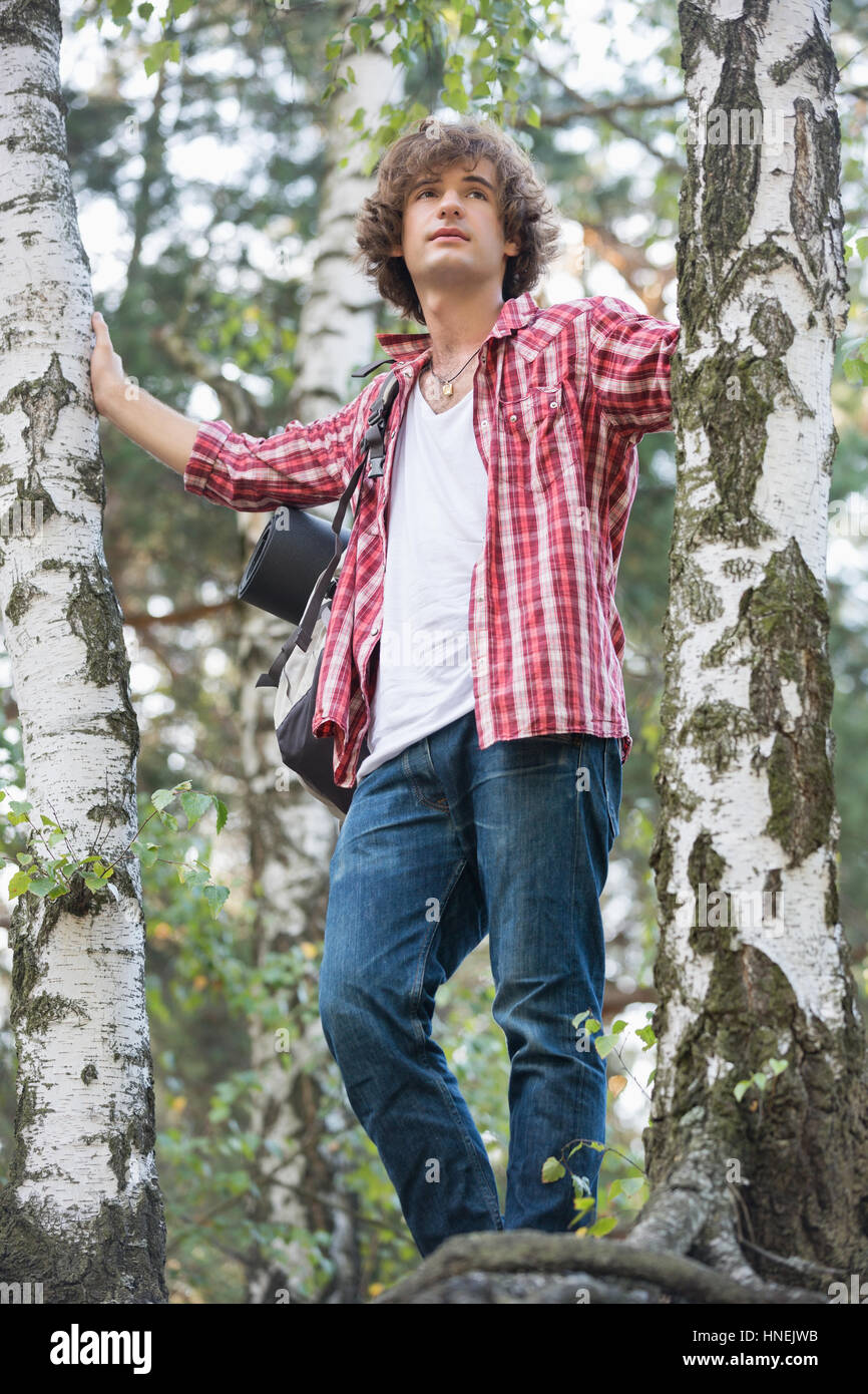 Young male hiker standing in forest Stock Photo