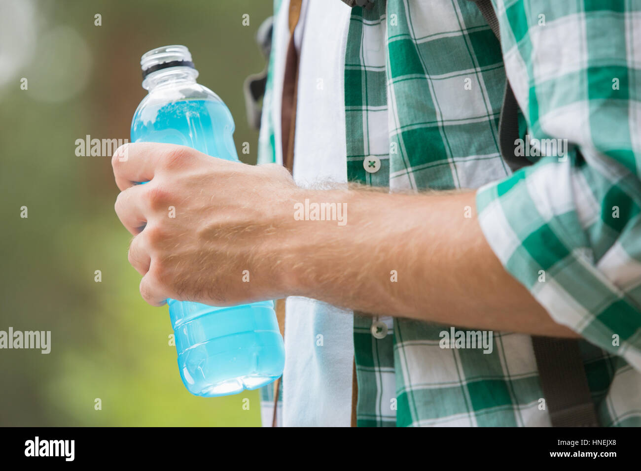 Midsection of man with energy drink outdoors Stock Photo