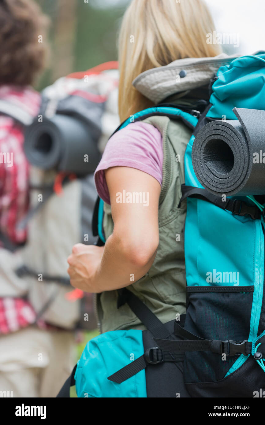 Rear view of female hiker carrying backpack with man in background outdoors Stock Photo